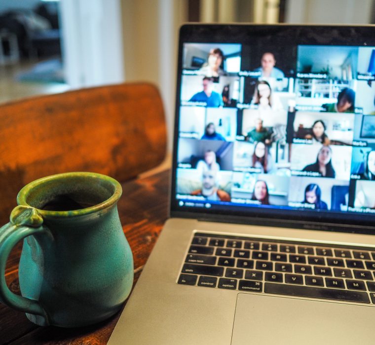 Mug next to a laptop showing people on an online video call